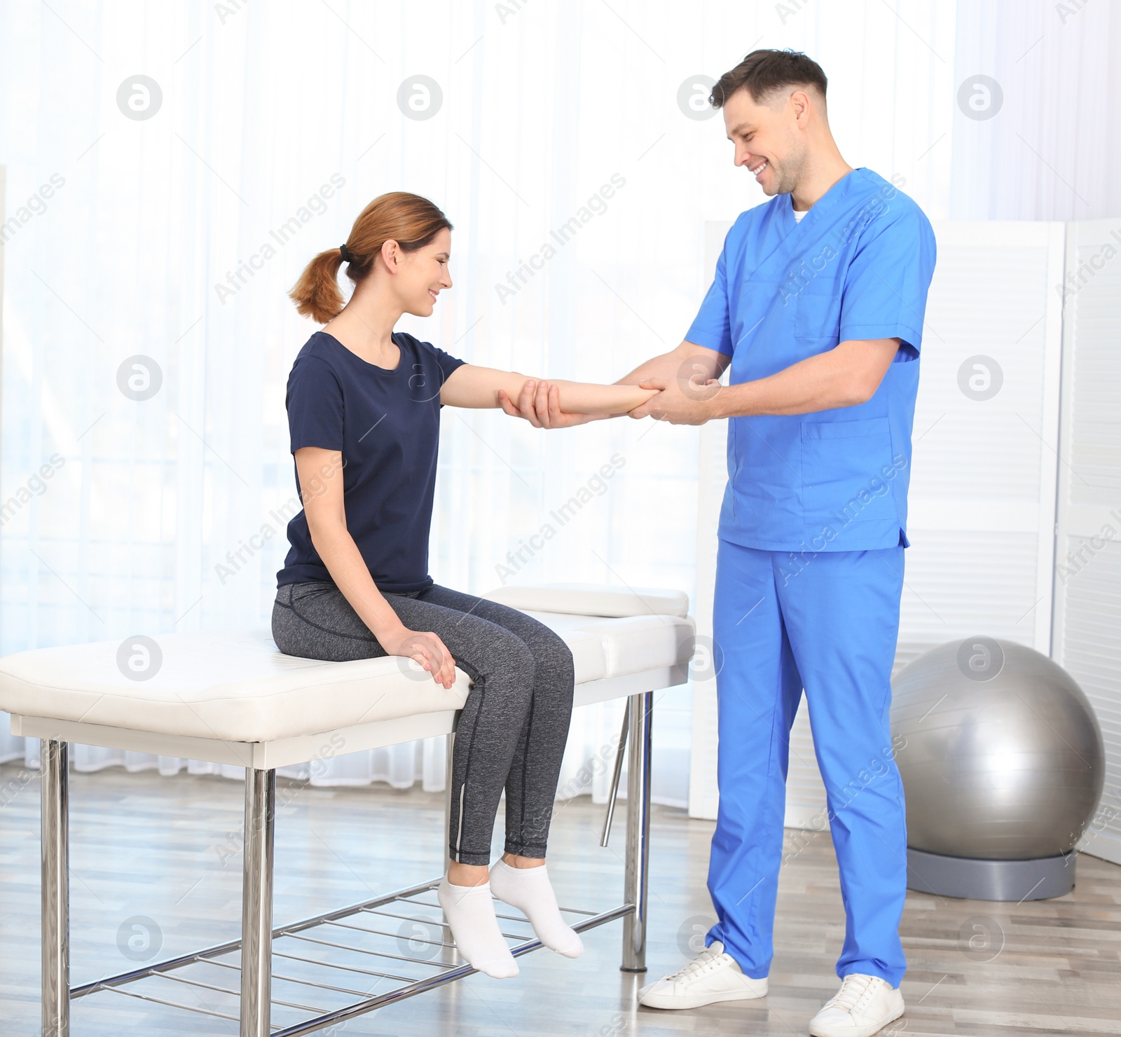 Photo of Physiotherapist working with patient in clinic. Rehabilitation therapy