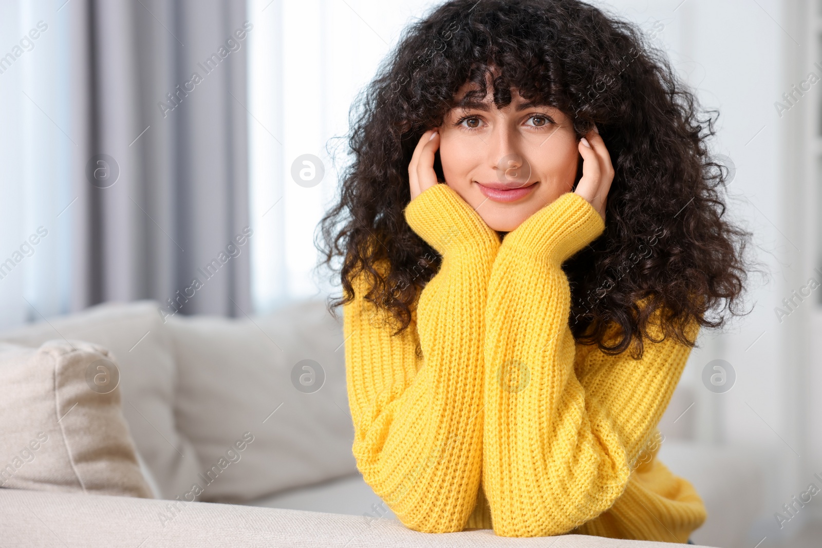 Photo of Young woman in stylish yellow sweater indoors, space for text