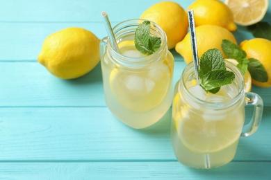 Photo of Natural lemonade with mint on light blue wooden table, closeup. Summer refreshing drink