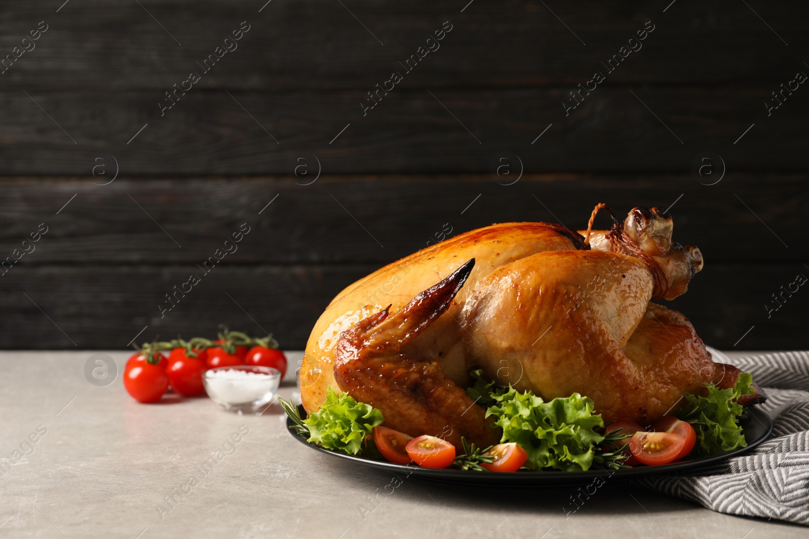 Photo of Platter of cooked turkey with garnish on table. Space for text