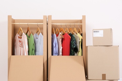 Photo of Wardrobe boxes with clothes on light background