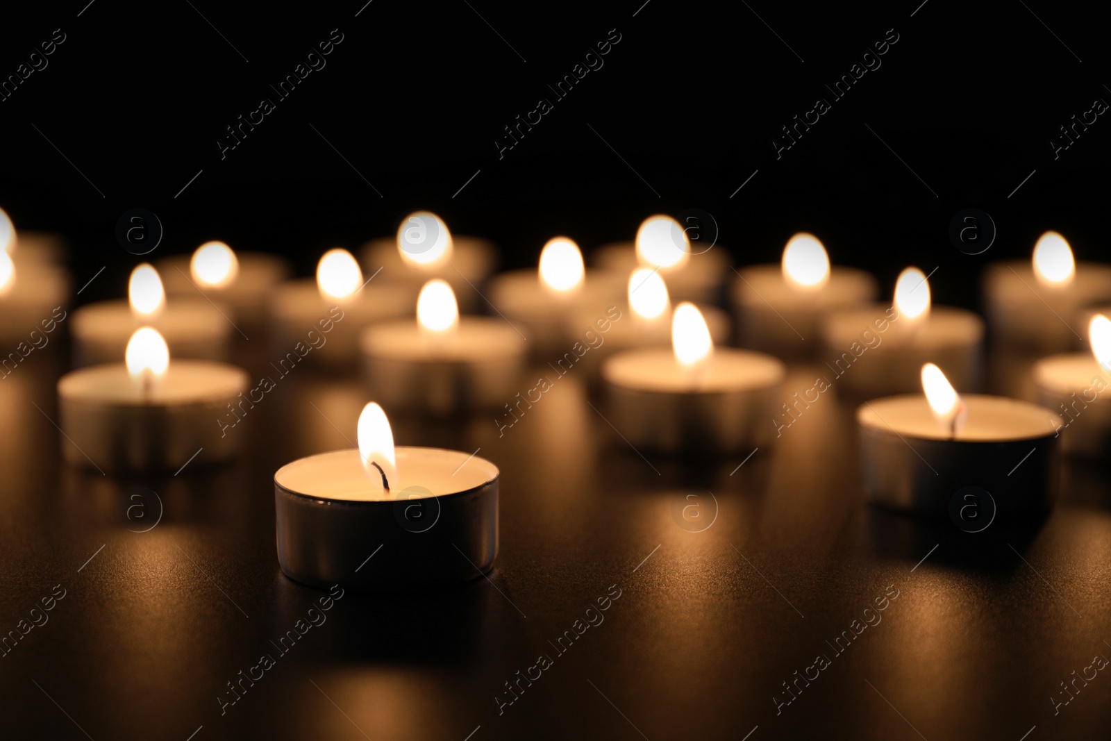 Photo of Burning candles on table in darkness, space for text. Funeral symbol