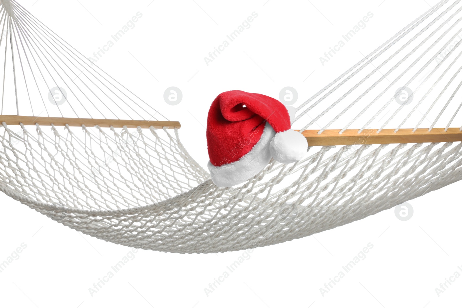 Photo of Comfortable hammock and Santa Claus hat on white background. Christmas vacation