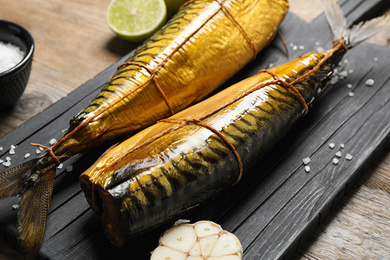 Tasty smoked fish on wooden table, closeup