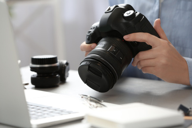 Journalist with camera working at table, closeup