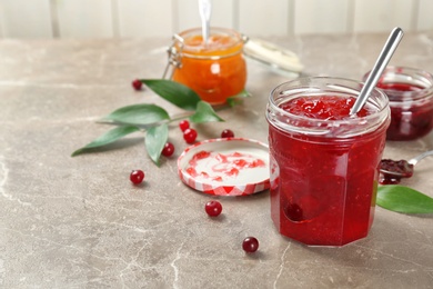 Jar with tasty sweet jam on table