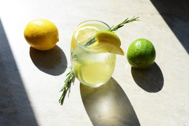 Photo of Tasty refreshing lemonade and ingredients on light table. Summer drink