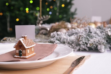 Beautiful festive place setting with blank card and decor for Christmas dinner on table, closeup. Space for text