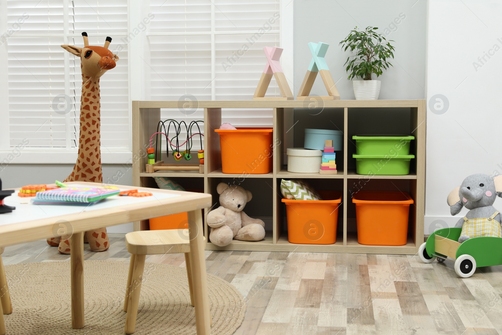 Photo of Cute child's room interior with toys and wooden furniture