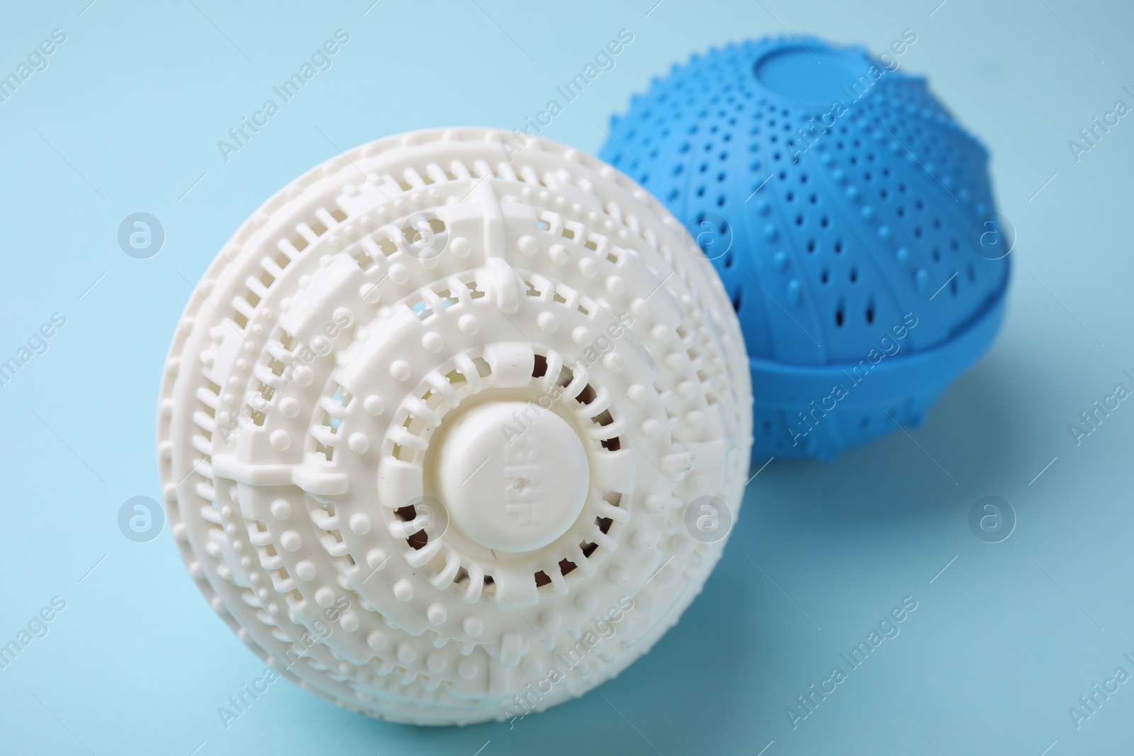 Photo of Dryer balls for washing machine on light blue background, closeup