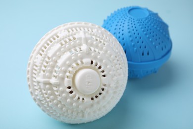Photo of Dryer balls for washing machine on light blue background, closeup