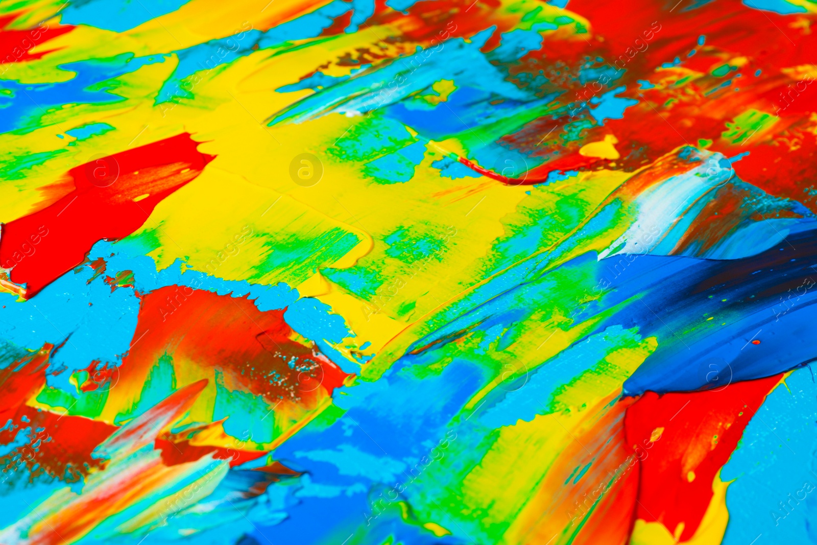 Photo of Closeup view of artist's palette with mixed bright paints as background