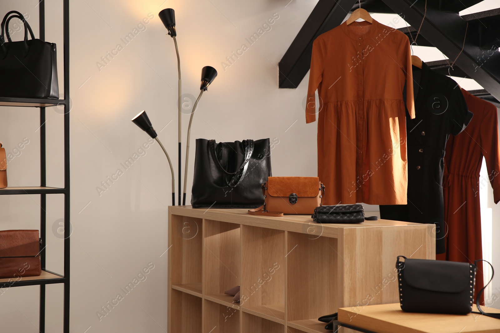 Photo of Collection of stylish women's clothes, bags and accessories in luxury boutique