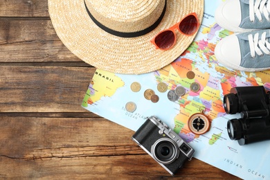 Photo of Flat lay composition with world map and different travel accessories on wooden table. Planning summer vacation trip