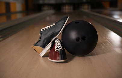 Shoes and ball on bowling lane in club