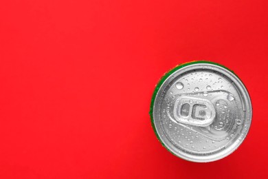 Photo of Energy drink in wet can on red background, top view. Space for text