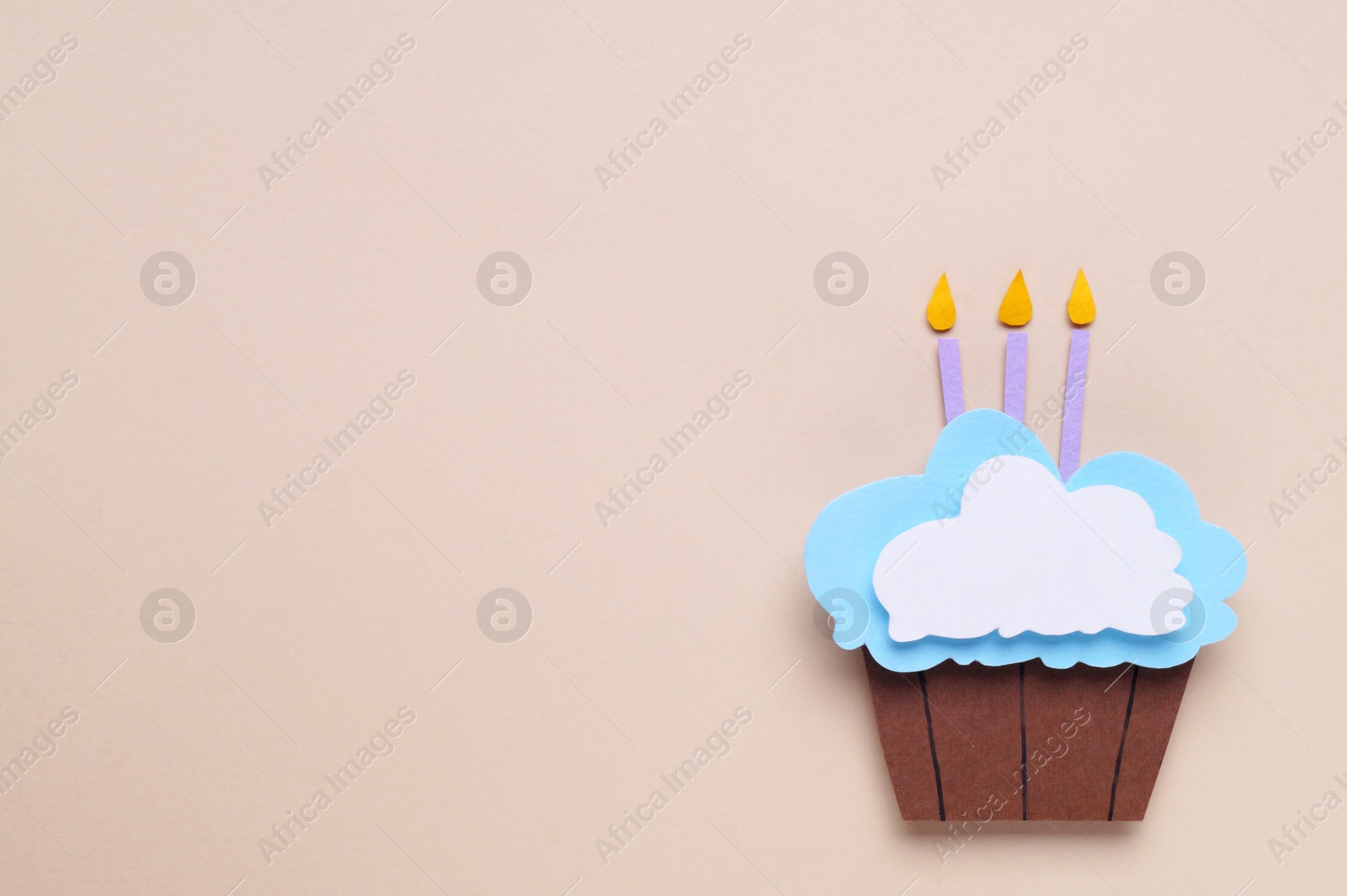 Photo of Birthday party. Paper cupcake with candles on beige background, top view and space for text