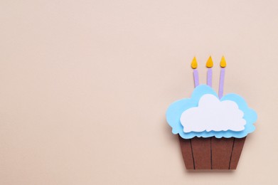 Birthday party. Paper cupcake with candles on beige background, top view and space for text