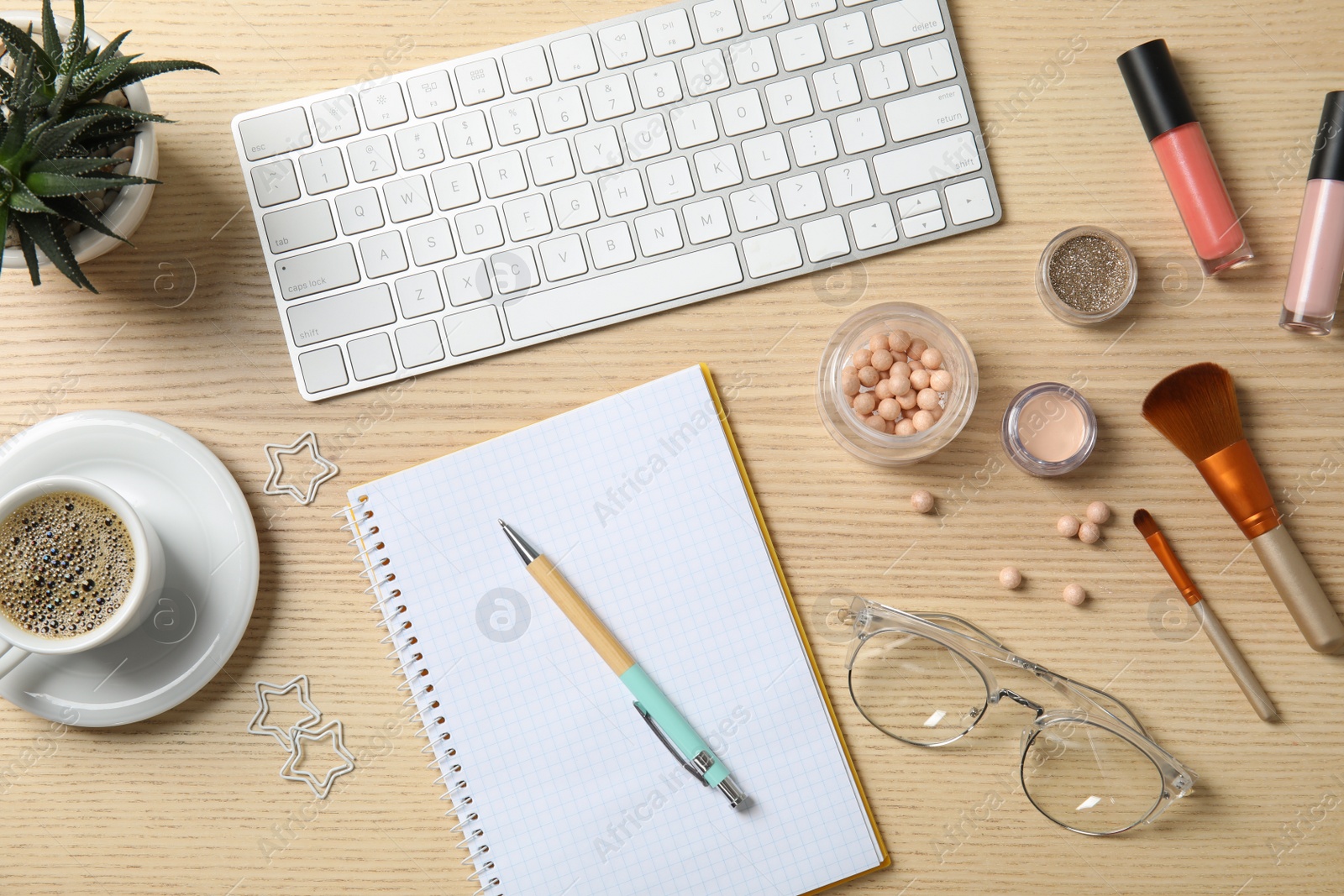 Photo of Flat lay composition with computer keyboard, cosmetics and notebook on wooden table. Blogger's workplace