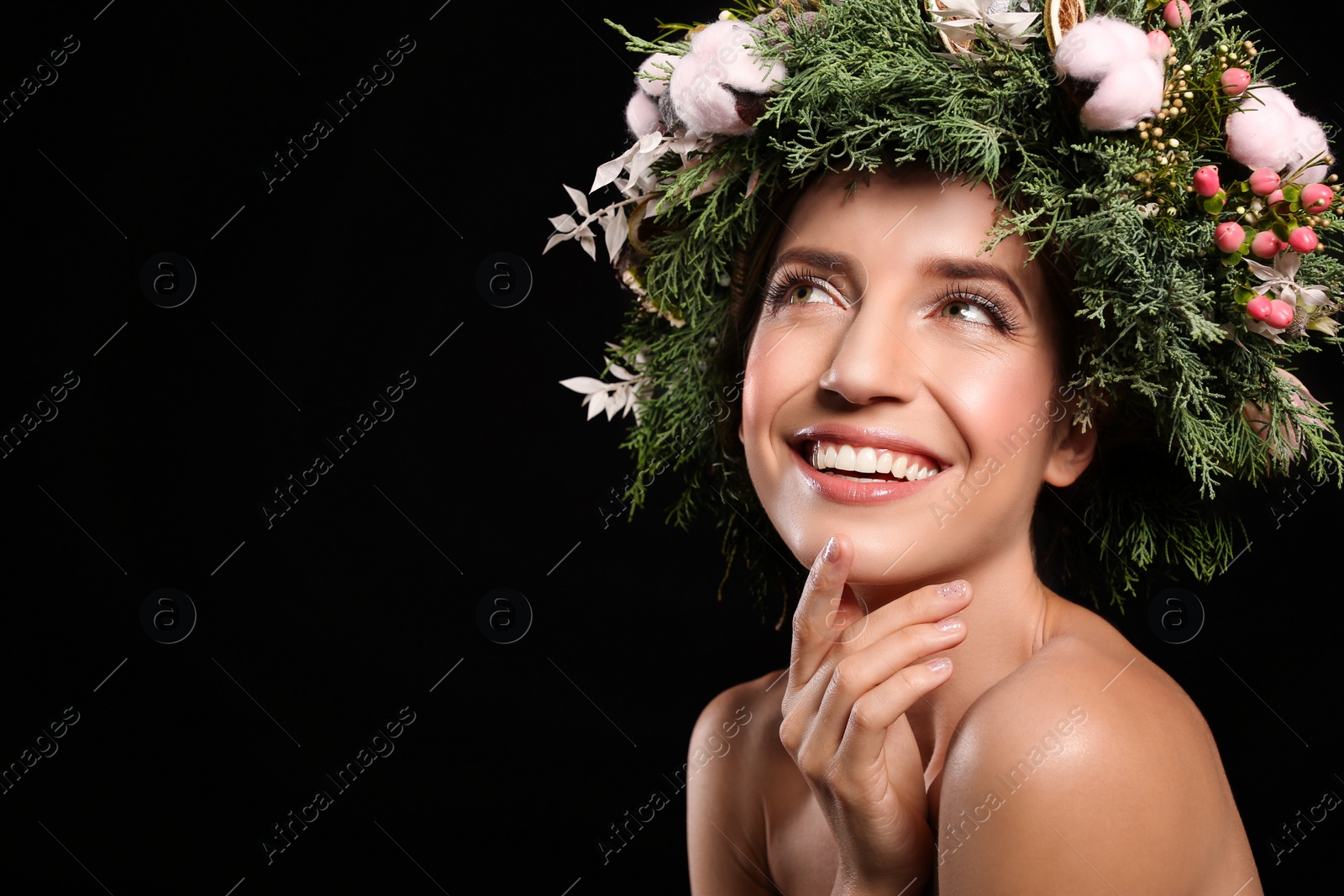 Photo of Happy young woman wearing wreath on black background. Space for text