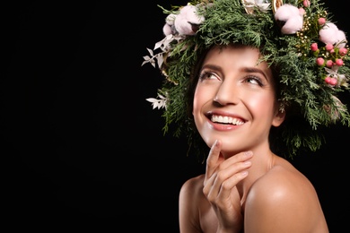 Photo of Happy young woman wearing wreath on black background. Space for text