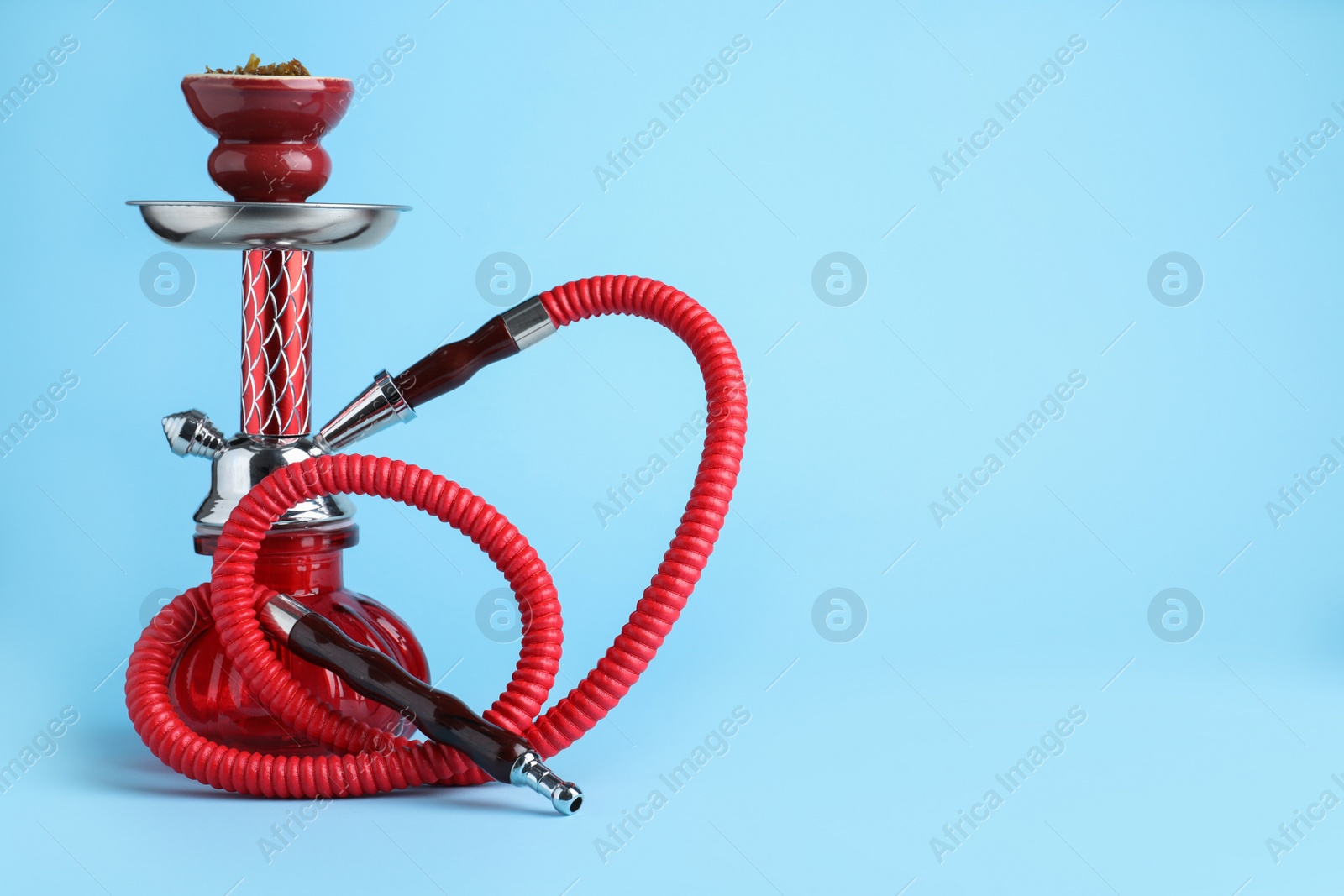 Photo of Modern red hookah on light blue background, space for text