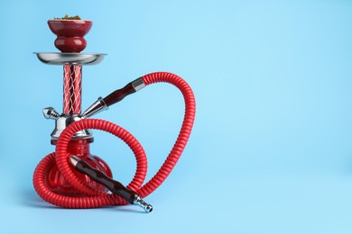 Modern red hookah on light blue background, space for text