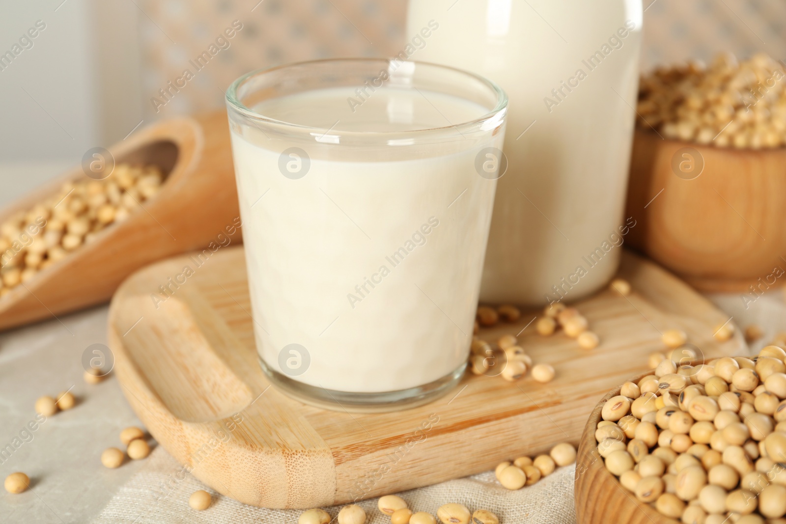 Photo of Fresh soy milk and beans on light grey table