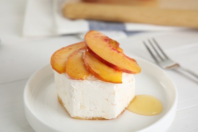 Photo of Delicious dessert with peach slices on plate, closeup
