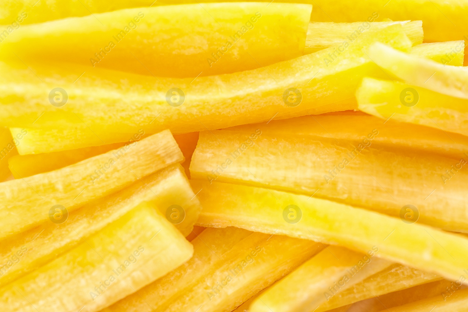 Photo of Raw yellow carrot sticks as background, closeup