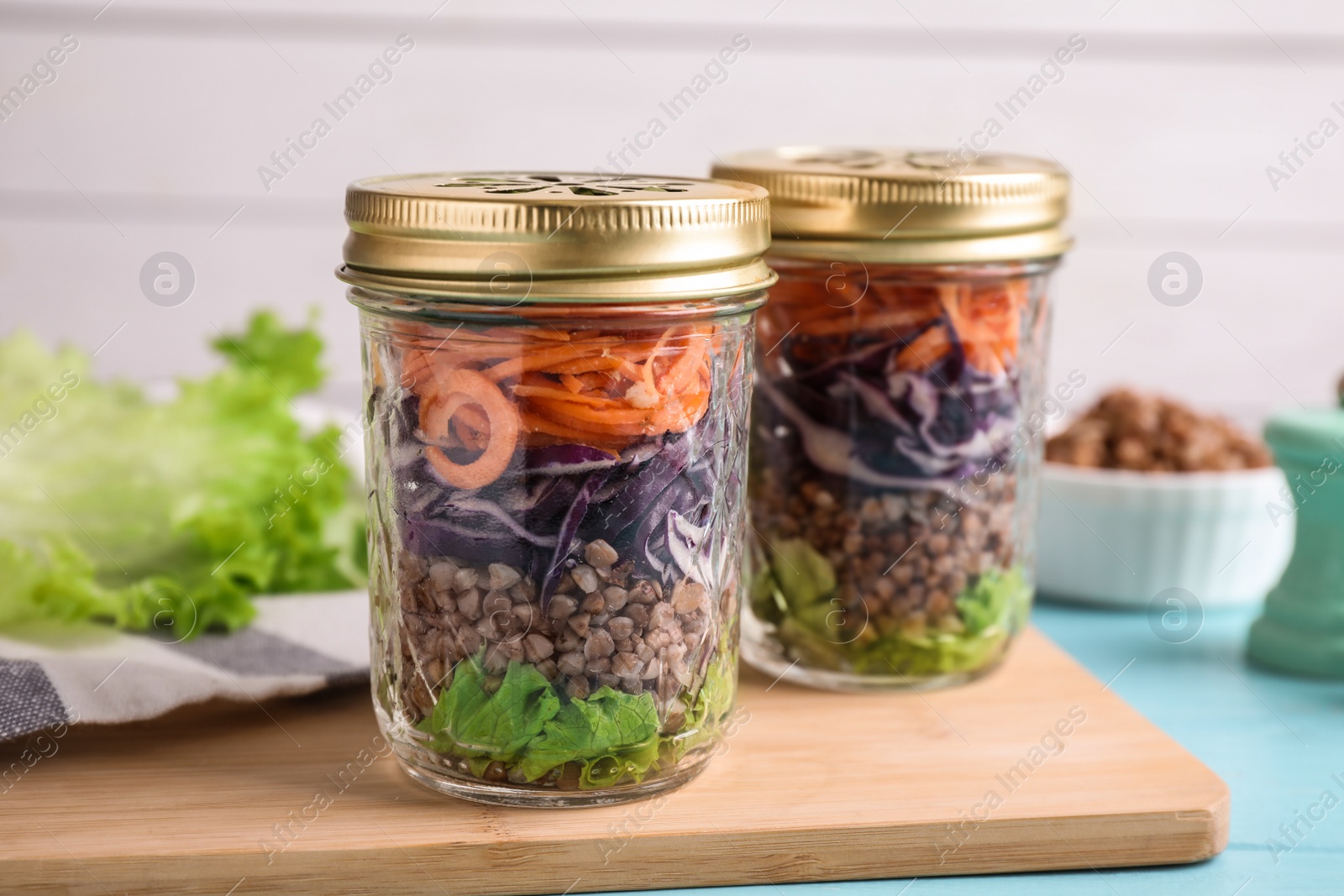 Photo of Glass jars with healthy meal on light blue wooden table