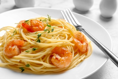 Plate with spaghetti and shrimps on table