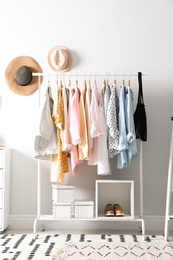 Photo of Rack with stylish women's clothes indoors. Interior design