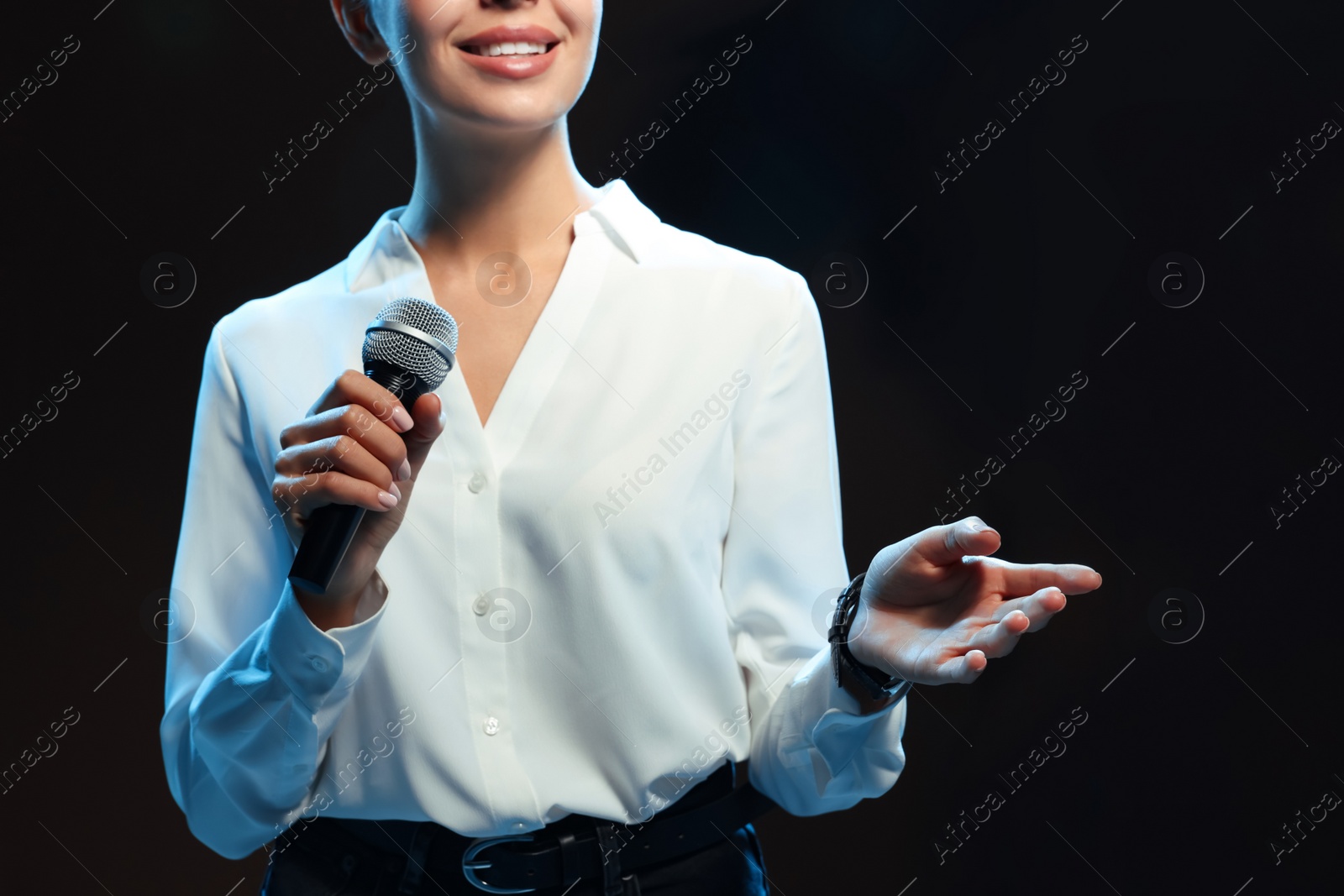 Photo of Motivational speaker with microphone performing on stage, closeup