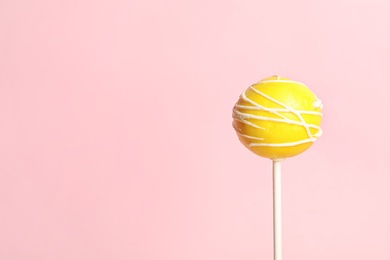 Photo of Bright delicious cake pop on color background. Space for text