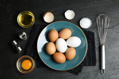 Photo of Flat lay composition with chicken eggs on black table