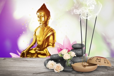 Image of Composition with smoldering incense sticks on wooden table and Buddha figure on background. Space for text