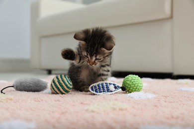 Photo of Little kitten playing with toys at home