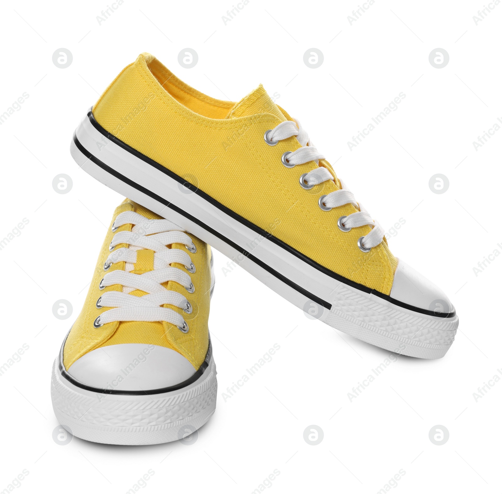 Photo of Pair of yellow classic old school sneakers on white background