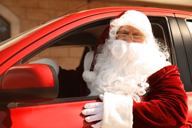 Authentic Santa Claus driving his modern car, outdoors