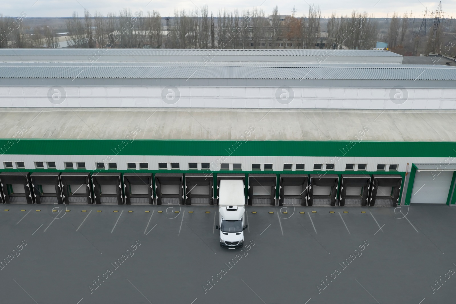 Image of Truck near loading dock of warehouse outdoors, aerial view. Logistics center