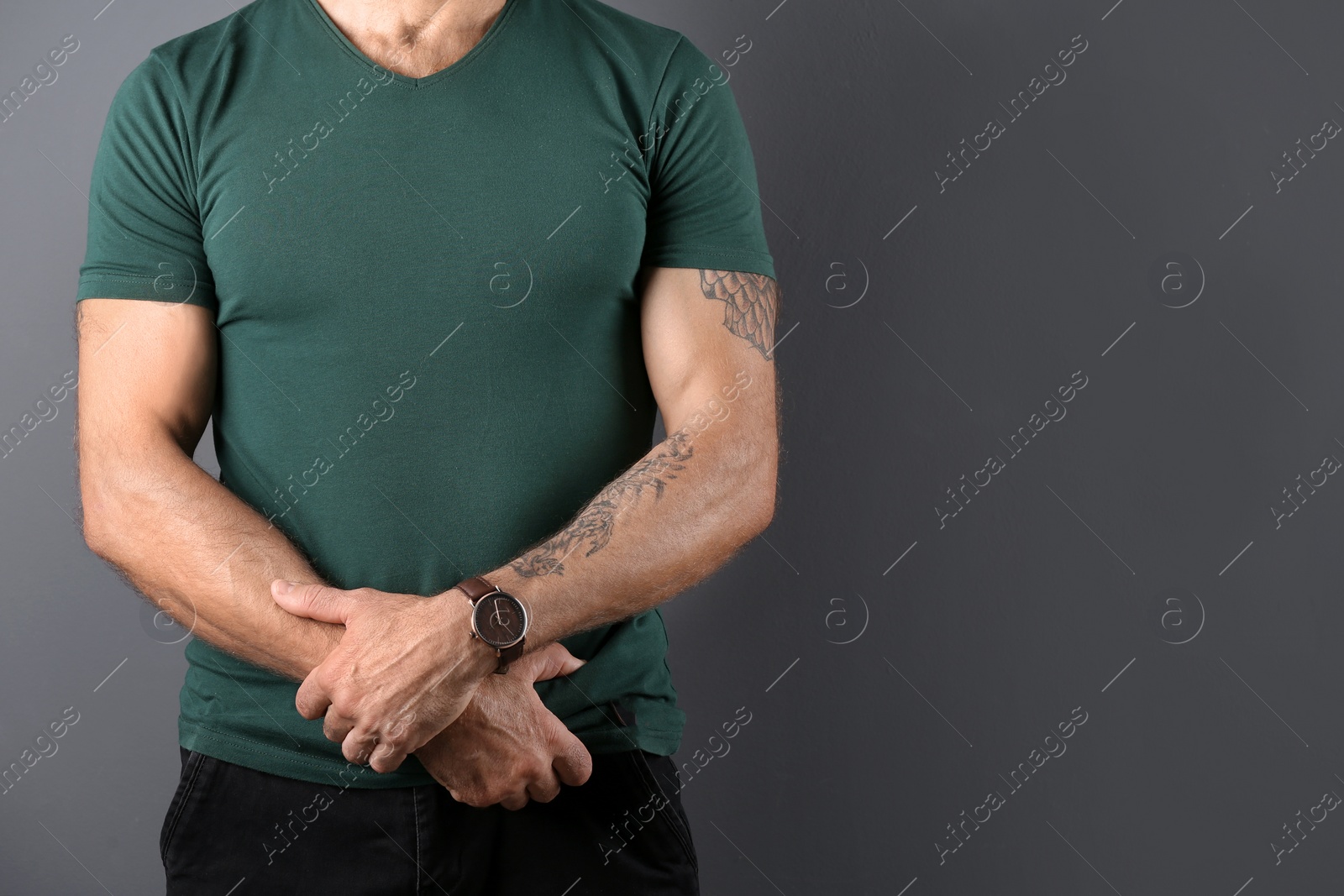 Photo of Closeup view of tattooed man on grey background. Space for text