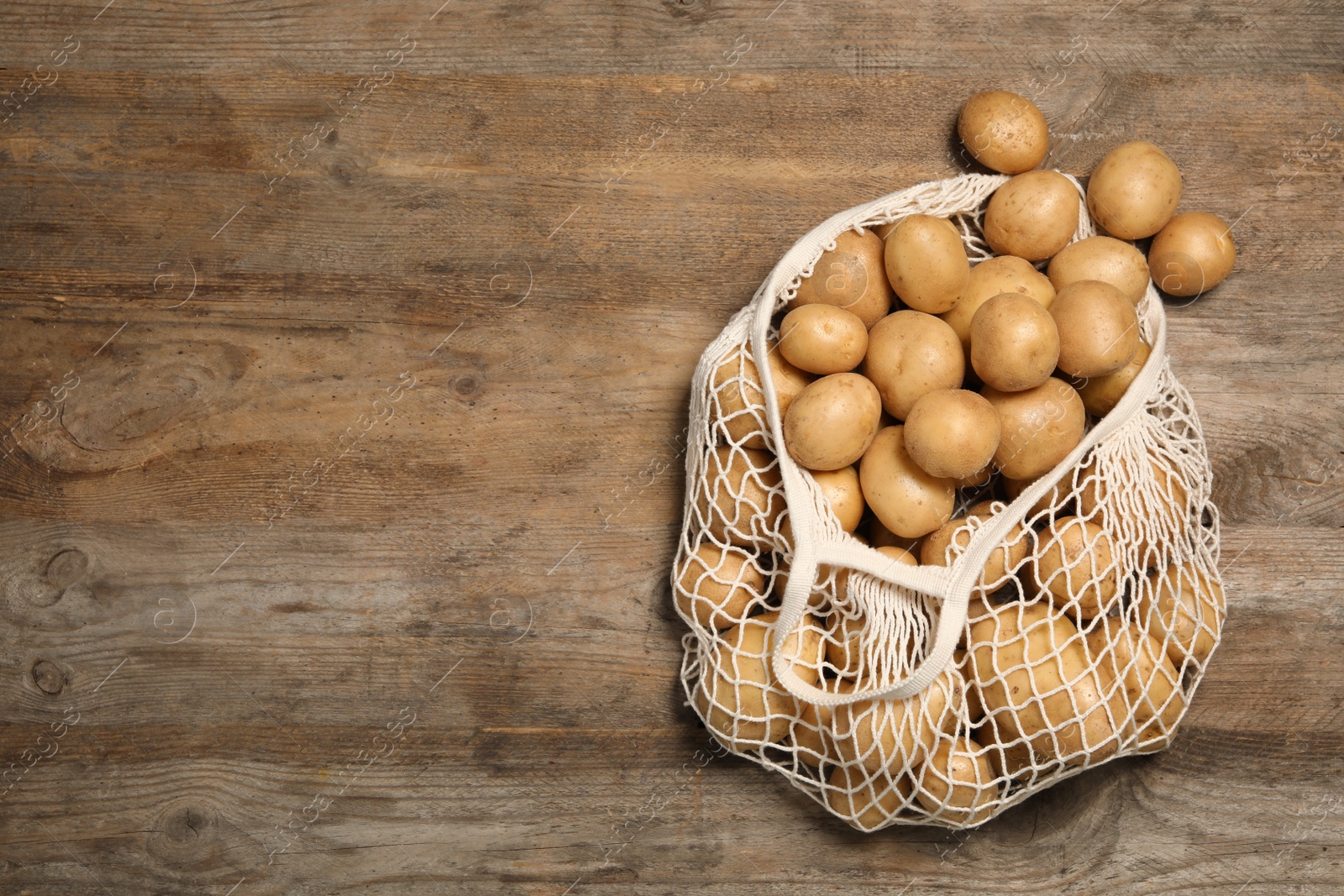 Photo of Raw fresh organic potatoes on wooden background, top view. Space for text