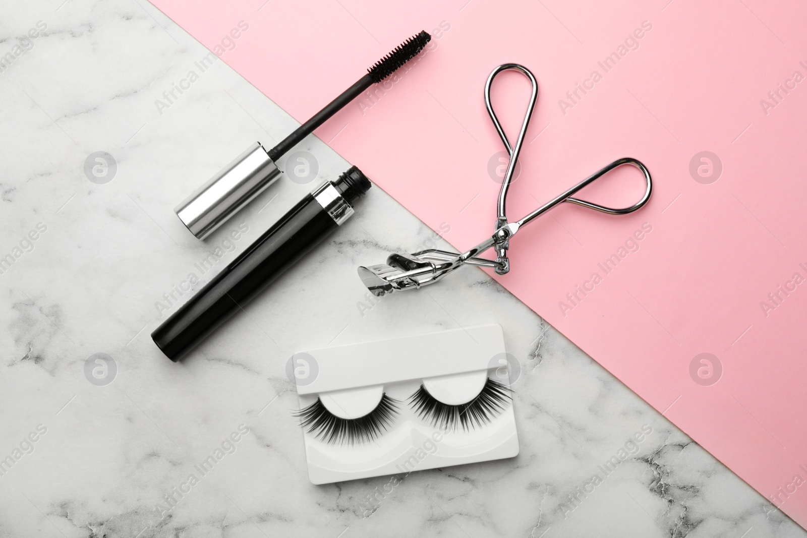 Photo of Artificial eyelashes and accessories on color background, flat lay