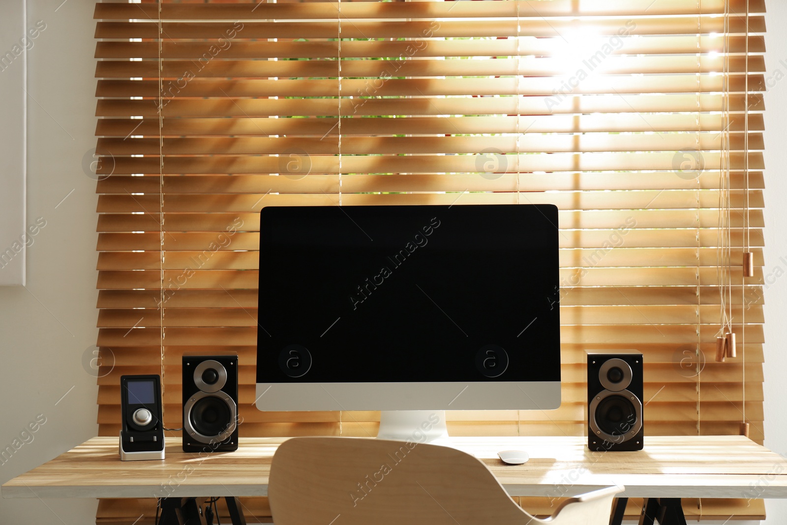 Photo of Modern computer with audio speakers and remote on table indoors