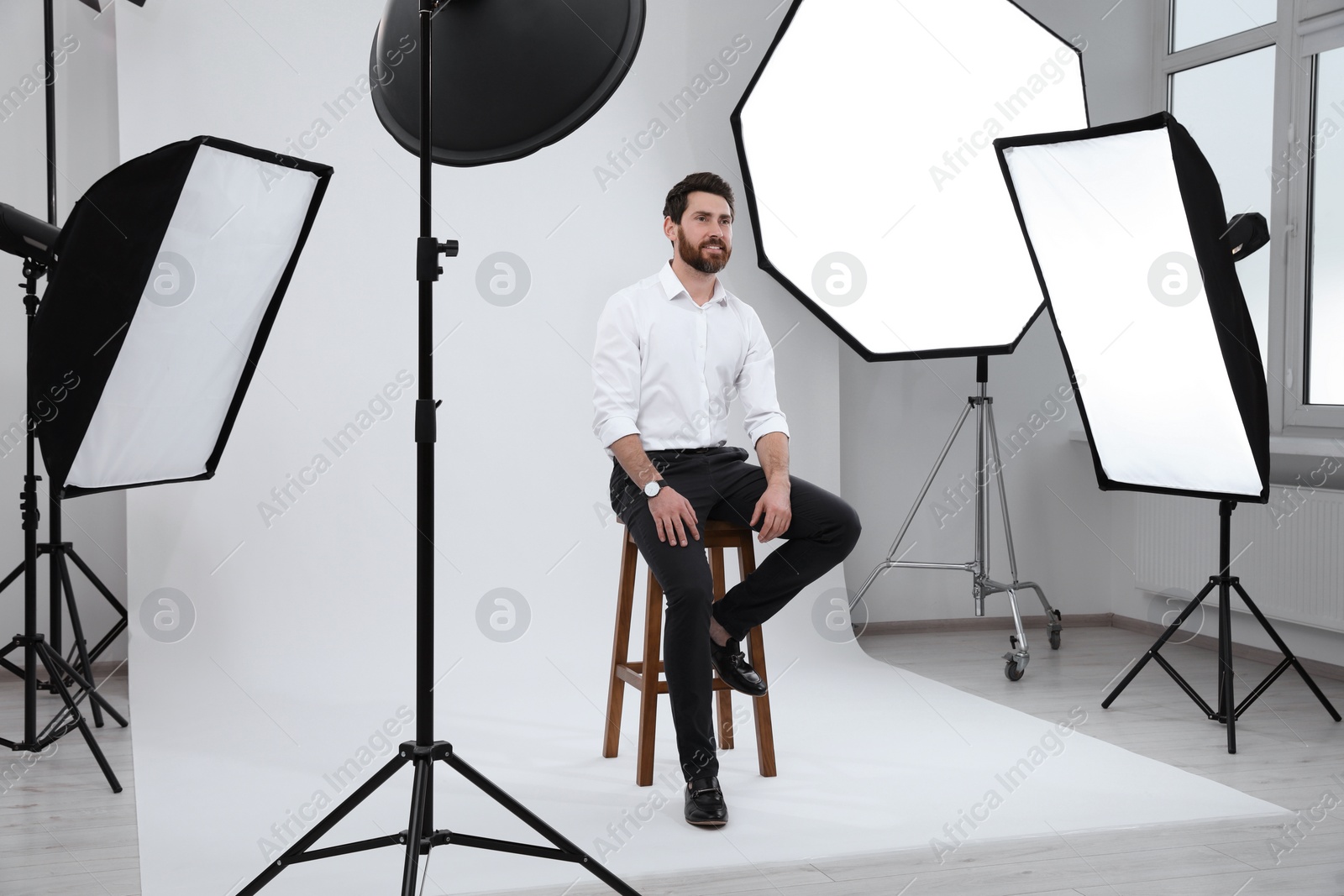 Photo of Handsome model posing in modern studio. Professional photo session