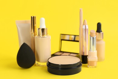 Photo of Foundation makeup products on yellow background. Decorative cosmetics