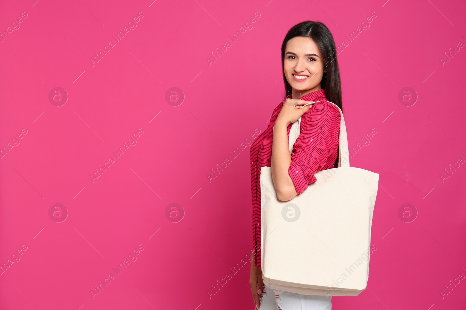 Photo of Beautiful young woman with stylish blank eco bag against color background, space for text