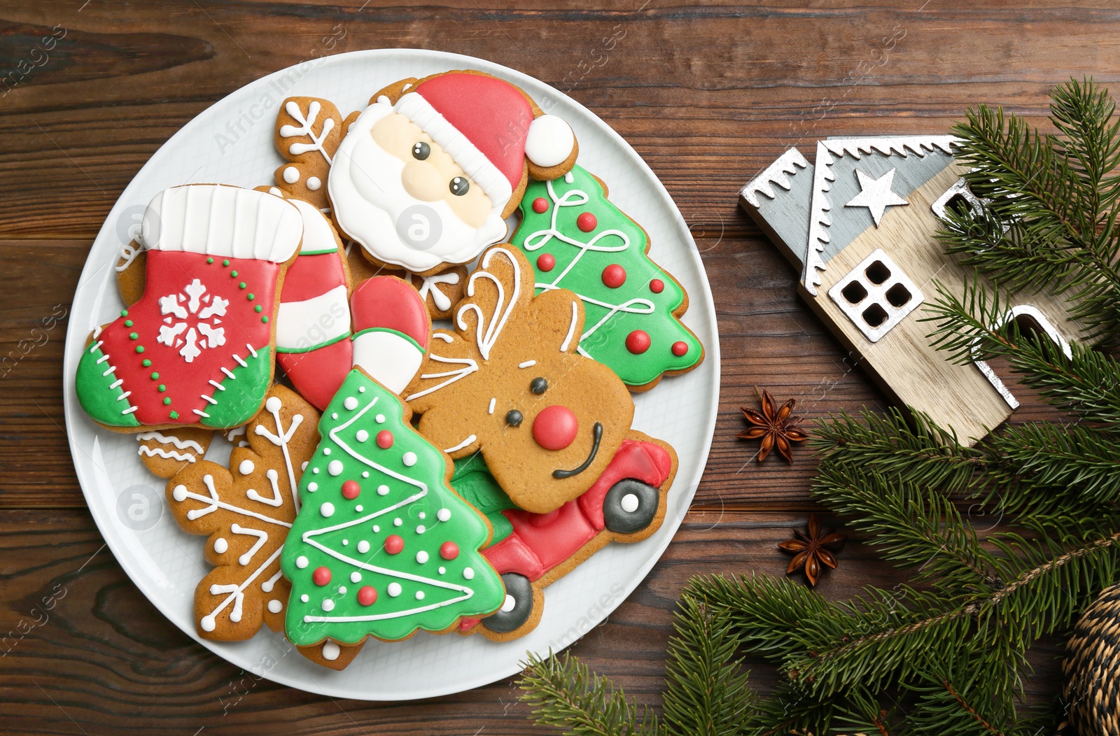 Photo of Different tasty Christmas cookies and festive decor on wooden table, flat lay