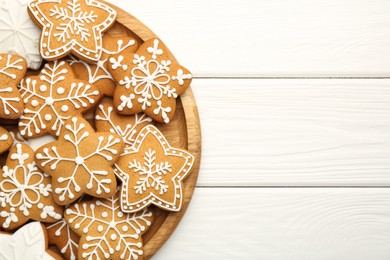 Photo of Tasty Christmas cookies with icing on white wooden table, top view. Space for text